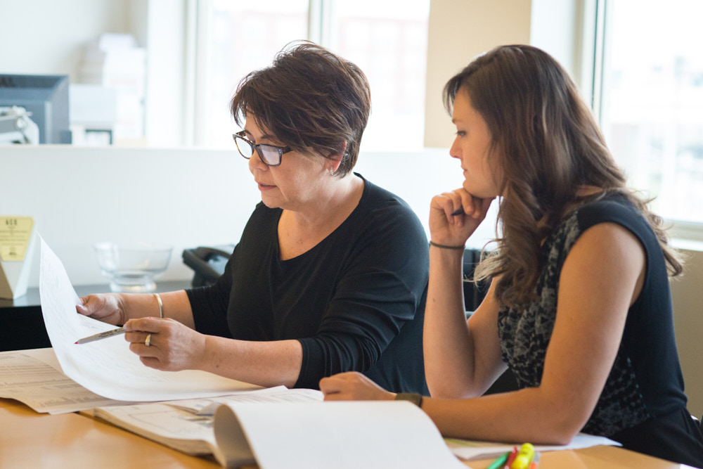 Two architects collaborate on a document in an office